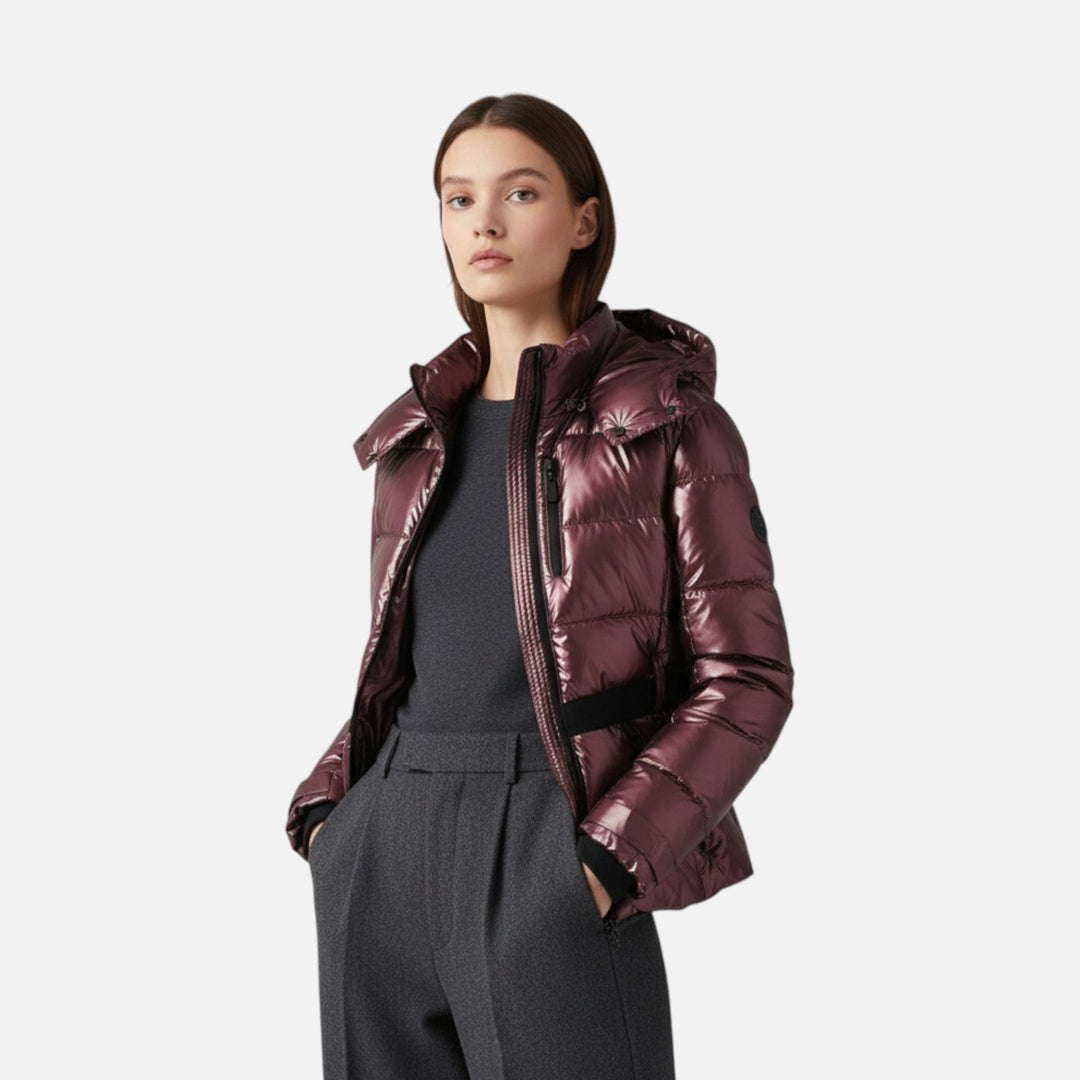 Woman wearing a maroon puffer jacket on a white background